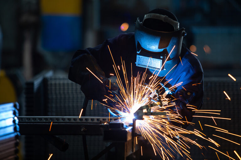 Workers wearing industrial uniforms and Welded Iron Mask at Stee